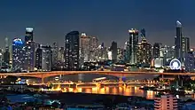 View of the Krung Thep Bridge at night with many skyscrapers in the background