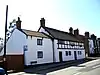 A pair of two-storey rendered cottages with a timber-framed upper floor