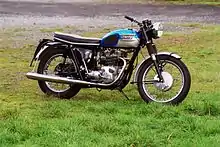 Blue-and-white motorcycle, parked on grass