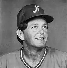 A man in a dark baseball uniform and cap