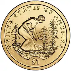 2009 US Sacagawea dollar coin depicting a woman in a buckskin tunic planting seeds among cornstalks and squash plants