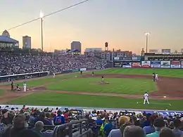 A green baseball field at dusk