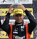 Ryō Hirakawa celebrating in black and orange overalls