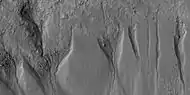 Close view of gullies from previous image The channels are quite curved.  Because channels of gullies often form curves, it was thought that they were made by flowing water.  Today, it is thought that they could be produced with chunks of dry ice.  The image is from HiRISE under HiWish program.