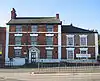 A Georgian house with three storeys and three bays, and with a two-bay two-storey extension on the right