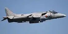 Starboard view of grey jet aircraft in-flight against a blue sky