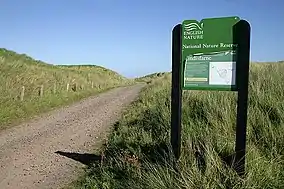 A sign for the reserve, next to a path