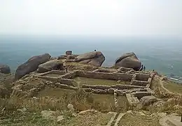 Ancient ruins, walls, and great boulders on the slope of a hill