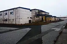 A series of large concrete buildings with peeling paint, clearly in a state of disrepair