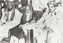 Photo of three men seated, on the right is Mishaal