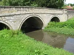 Aberford Bridge over the Cock Beck. The arches show the former width