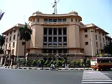 A five-storied building in cream colour with multiple columns in front