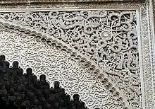 Arabesques carved in stucco over an archway in the al-Attarine Madrasa in Fes