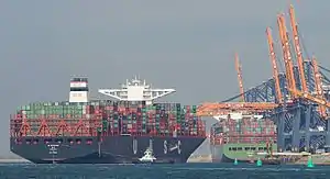 Cargo ships loaded with shipping containers near cranes at a port