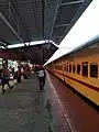 Kannur-Alappuzha Express parked on platform 2 of Thrissur railway station with golden sunlight of the evening sun reflecting off it.