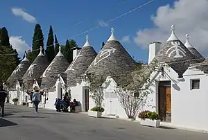 Small white houses with conic roofs.