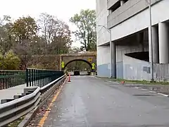 A sidewalk and road next to a parking garage