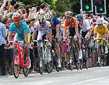 A cyclist riding a bike while wearing a skinsuit and an aerodynamic helmet.