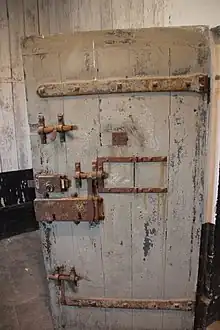 Color photograph of a strong wooden door with multiple locks and bolts.