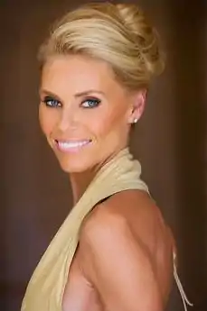 Portrait photograph of Anna Anka from left side wearing a dress and her blonde hair up in a bun