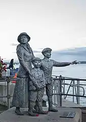 Statue of Annie Moore and her brothers on the quayside in Cobh, Ireland.