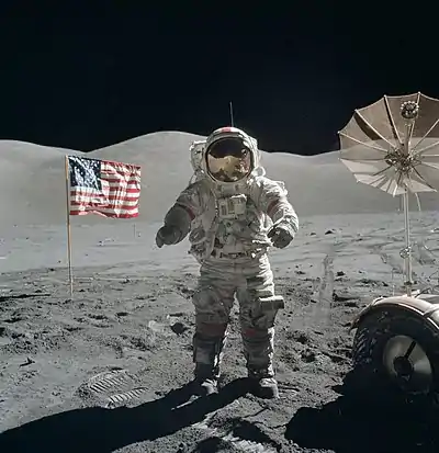 A man standing on the moon with an American flag in the background