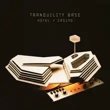 A rough cardboard model of a hotel placed on top of a tape recorder. At the top of the image, "Tranquility Base Hotel + Casino" is written in all caps.