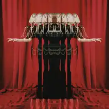 An edited photograph of Aurora that shows several reflections of her with a dark green dress, while standing on tiptoes. Behind her is a backdrop of red curtains that also cover the lower corner of the image.