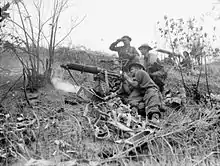 Soldiers firing a medium machine from the slope of a hill