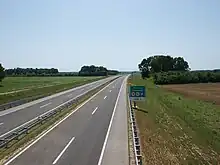 A view of the motorway, a rest area approach traffic sign is located on the right side of the road