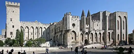 A large robust stone building with one large and two smaller towers