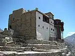 A large stone and timber fort with white front facade