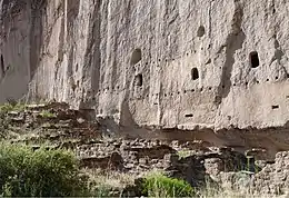 A Remains of multistory dwelling built into volcanic tuff wall, Bandelier National Monument, New Mexico