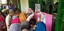 People looking for their names in an elementary school serving as a polling place as part of the plebiscite voting process