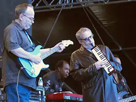 Steely Dan performing in 2007.  Walter Becker (l) playing electric guitar, Donald Fagen (r) playing melodica.