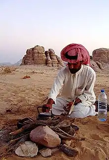 A young Bedouin lighting a camp fire in Wadi Rum, Jordan.