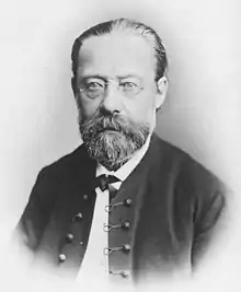  Portrait of balding, bearded, bespectacled middle-aged man with solemn expression, wearing a bow tie and high-buttoned jacket