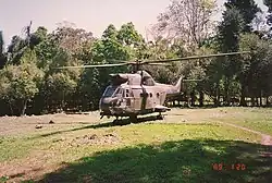 A large helicopter in a jungle clearing.