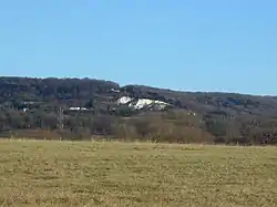 A wooded hill pictured against the sky.