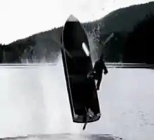 A boat exploding upward from a lake.