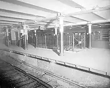 Black-and-white image of the Bowling Green station platform, with a track in the foreground