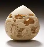 Jewel of Wisdom carved with mountain pavilions. Stained ivory