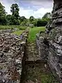 Undercroft of lay brother's range and gap giving entrance to cloister, showing how the building lay behind the cloister itself.