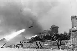 A 28/32 cm rocket in flight during the Warsaw Uprising, with piles of spent cases on the right