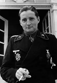 A man wearing a military uniform with an Iron Cross displayed at the front of his uniform collar.