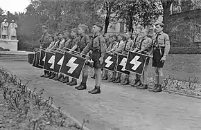 Young boys marching with a trumpet at a garden.