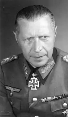 A man wearing a military uniform with an Iron Cross displayed at the front of his uniform collar.