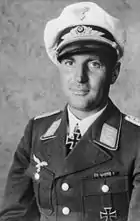 A man wearing a military uniform with an Iron Cross displayed at the front of his uniform collar.