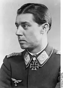 A man wearing a military uniform with an Iron Cross displayed at the front of his uniform collar.