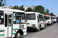 Double-door buses in Tomsk. Red gas cylinders uses for methane gas fuel